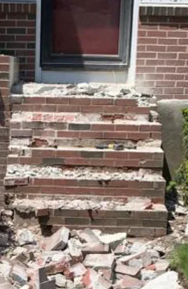 Deteriorated brick entry steps with crumbling mortar, before rebuilding