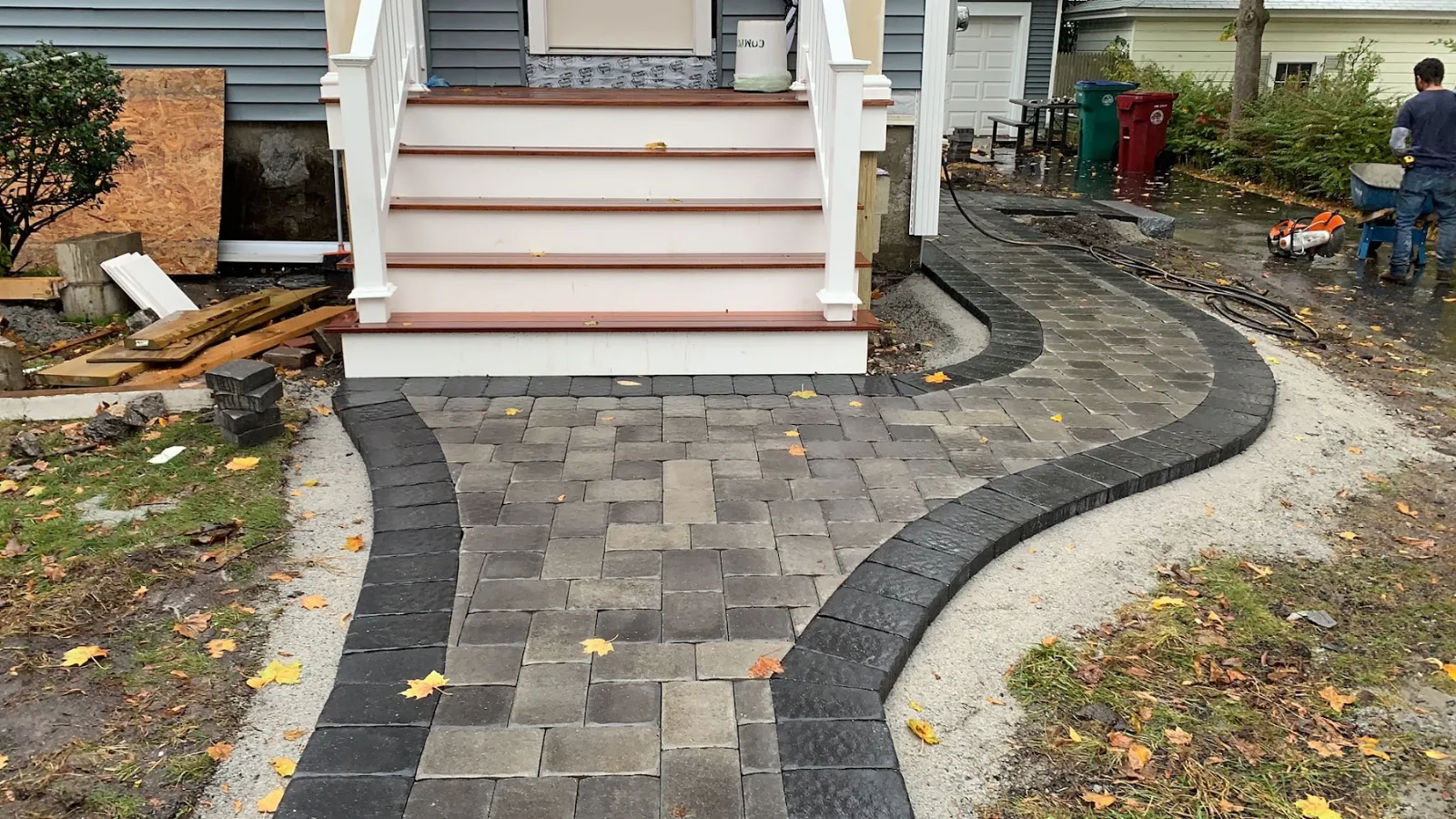 Curved paver walkway with a dark contrasting border leading to front porch steps
