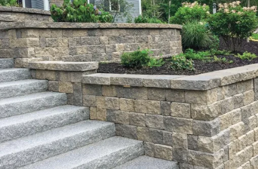 Two tiers of segmental block retaining wall with granite steps running between them